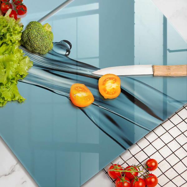 Skärbräda glas Vatten på en blå bakgrund