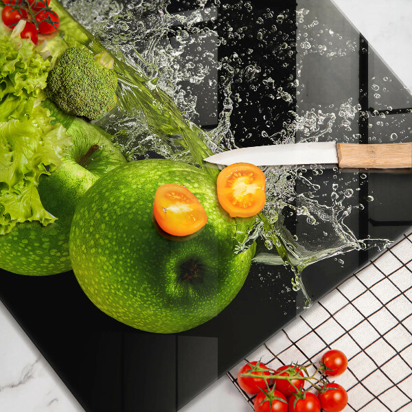 Skärbräda av glas Gröna äpplen och vatten